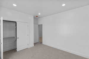 Bedroom 2 with carpet floors, recessed lighting, and a closet