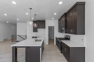Kitchen with appliances with stainless steel finishes, recessed lighting, dark brown cabinets, and light countertops