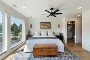 Bedroom with wood finished floors, recessed lighting, connected bathroom, and a ceiling fan