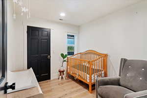 Bedroom with light wood finished floors and recessed lighting