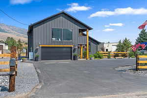 View of front of home with board and batten siding, a garage, and driveway