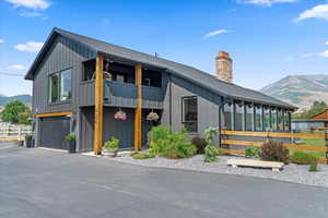 View of front of house featuring board and batten siding, a mountain view, a balcony, and an attached garage