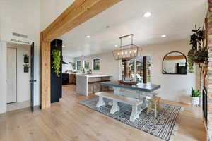 Dining room with light wood-style flooring, recessed lighting, plenty of natural light, a chandelier, and a fireplace