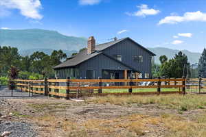 Rear view of house with a mountain view, board and batten siding, and a chimney