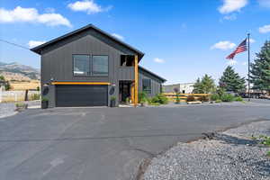View of front of property featuring driveway, board and batten siding, and a garage