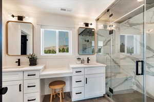Full bathroom featuring a marble finish shower, vanity, and tile patterned floors