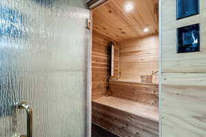 Relaxing sauna featuring wood ceiling, wood walls, and recessed lighting
