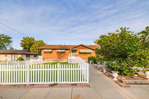 Bungalow-style house featuring a fenced front yard and brick siding