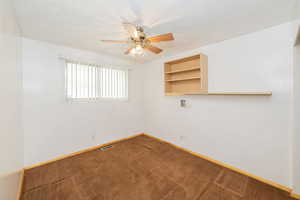 Carpeted spare room featuring a ceiling fan and a textured ceiling