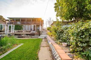 Back of property featuring stairs and a lawn