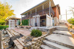 Rear view of house with stairway and a patio