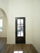 Doorway to outside featuring wood finished floors, plenty of natural light, and arched walkways