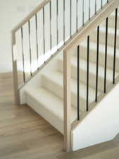 Stairway featuring wood finished floors
