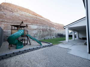 View of green lawn with a playground and a patio area
