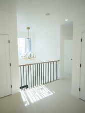 Hallway featuring a chandelier, carpet, and recessed lighting