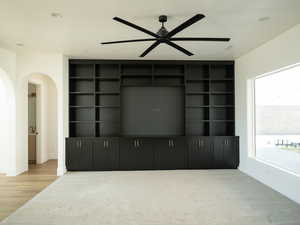 Unfurnished living room featuring arched walkways, a ceiling fan, recessed lighting, and wood finished floors