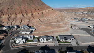 Aerial view of property and surrounding area with nearby suburban area and a mountain backdrop