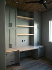 Unfurnished office featuring wood ceiling, dark wood finished floors, and built in study area