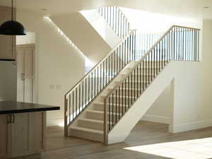 Staircase with wood finished floors and baseboards