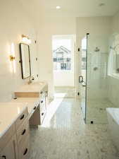 Bathroom with vanity, a soaking tub, a tile shower, and recessed lighting