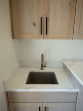 Kitchen featuring light brown cabinetry and light stone counters