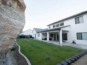 Back of house with stucco siding and a patio