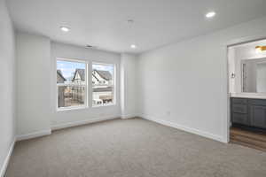 Unfurnished bedroom featuring carpet floors, recessed lighting, and ensuite bathroom