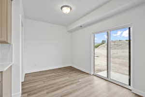 Unfurnished dining area featuring light wood-style floors and baseboards