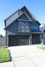 View of front of house with board and batten siding, concrete driveway, and an attached garage