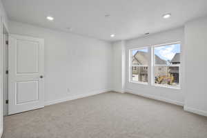 Carpeted empty room with baseboards and recessed lighting