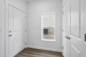 Doorway to outside featuring dark wood-style floors and baseboards