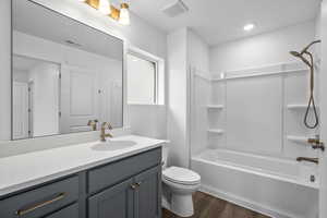 Bathroom with vanity, wood finished floors, and shower / tub combination