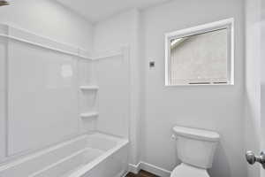 Bathroom featuring shower / washtub combination and wood finished floors