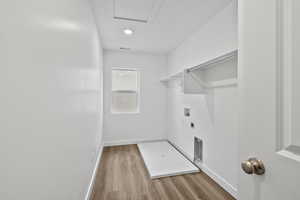 Laundry room with washer hookup, light wood-type flooring, hookup for an electric dryer, and recessed lighting