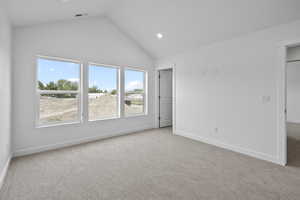 Unfurnished bedroom featuring carpet floors, vaulted ceiling, recessed lighting, and a spacious closet