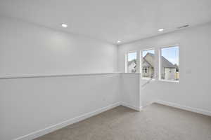 Carpeted empty room with baseboards and recessed lighting Loft