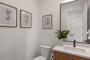 Half bath featuring toilet and vanity
