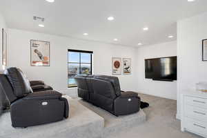 Cinema with light colored carpet and recessed lighting