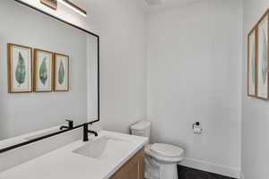 Half bath featuring toilet and vanity