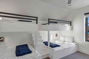 Carpeted bedroom with lofted ceiling