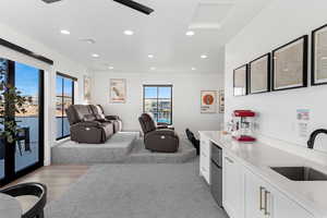 Kitchen with white cabinets, recessed lighting, light countertops, stainless steel refrigerator, and light colored carpet