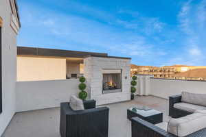 View of patio with an outdoor living space with a fireplace
