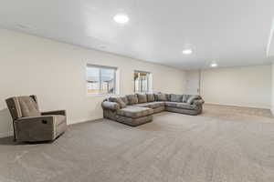 Carpeted living area featuring baseboards and recessed lighting