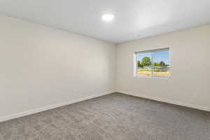 Empty room with dark carpet and baseboards
