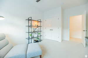 Living area featuring light carpet and baseboards