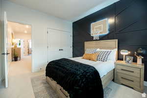 Bedroom with light carpet and a closet