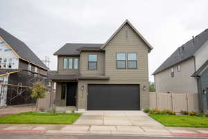 View of front of property with concrete driveway, a garage, and a gate