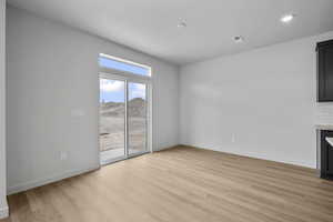 Unfurnished living room with light wood-type flooring, a mountain view, and recessed lighting
