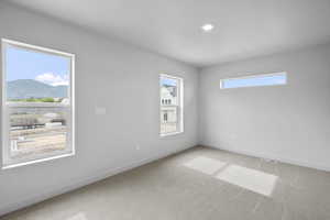 Unfurnished room with light colored carpet, a mountain view, and recessed lighting