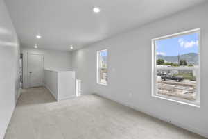 Loft. Spare room with carpet floors, recessed lighting, and a mountain view